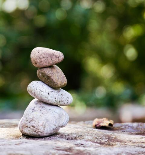 Koristekuva, kiviä tasapainotettu päällekkäin pinoksi kuten ahdistustakin pitää tasapainottaa.